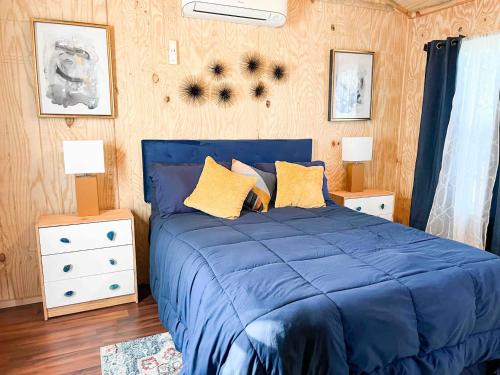 a blue bed with two night stands and two lamps at Big Bass Bungalow - Quitman Tx in Quitman