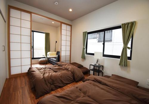 two beds in a room with two windows at WAMARE Shibamata, Entire private two-story house, Traditional Tokyo Stay with Easy Access to Haneda & Narita Airports, up to 4pax in Tokyo