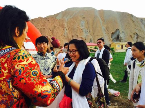 a woman standing next to a group of people at KaoShan Tent Zhangye in Zhangye