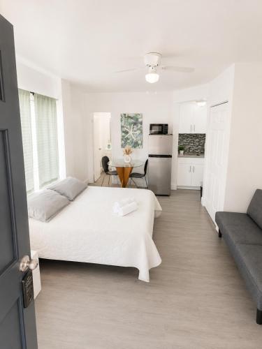 a white bedroom with a bed and a kitchen at Cozy studio in Hollywood 101 - 1 in Hollywood