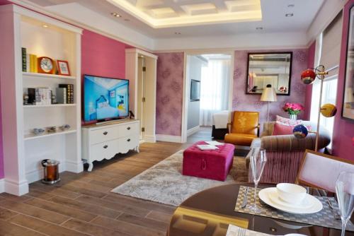 a living room with pink walls and a television at Hotel Madera Hollywood in Hong Kong