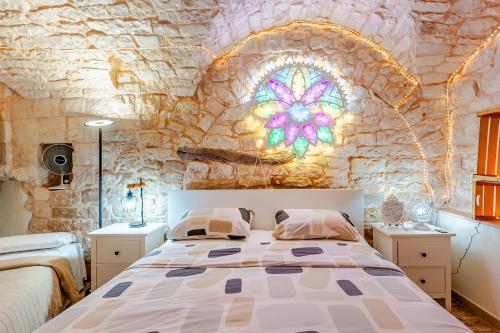 a bedroom with a bed and a stained glass window at Vitti Stone House - Centro Storico Castellana in Castellana Grotte