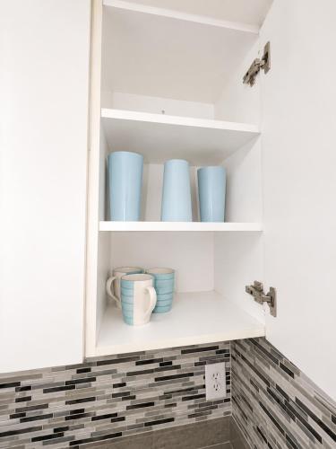 a cupboard with blue bowls and cups on it at Cozy studio in Hollywood 101 - 1 in Hollywood
