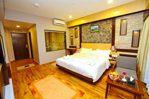 a bedroom with a large bed and a table at Hotel Queens Park in Pokhara