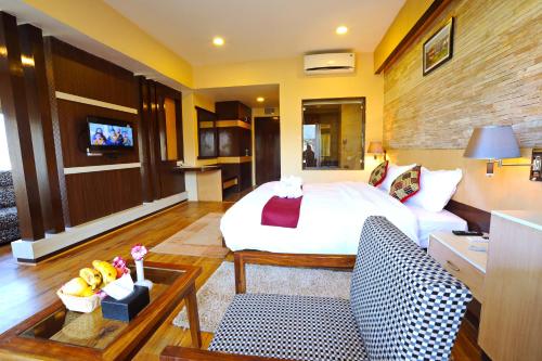 a bedroom with a bed and a living room at Hotel Queens Park in Pokhara