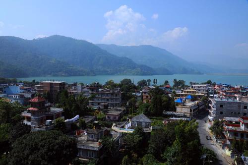 a city with a lake and mountains in the background at Hotel Queens Park in Pokhara