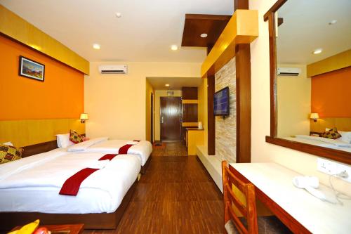 a row of beds in a hotel room at Hotel Queens Park in Pokhara