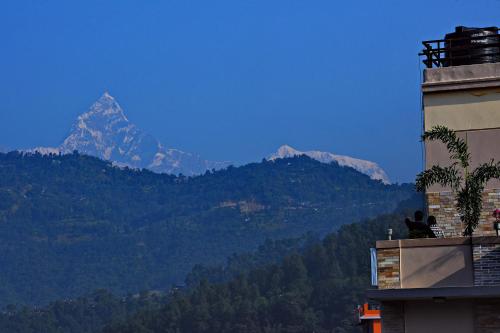 a view of a mountain from a building with a building at Hotel Queens Park in Pokhara