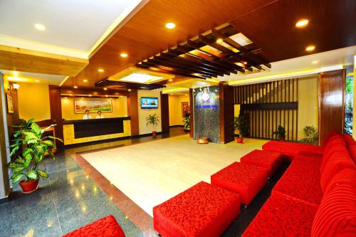 a lobby with red couches and a stage at Hotel Queens Park in Pokhara