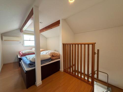 a small bedroom with a bed and a staircase at Villa Knossos in Higashiizu