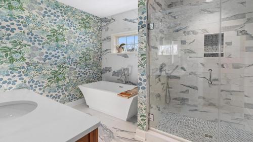 a bathroom with a shower and a sink and a tub at Welahpu Beach in Cape May