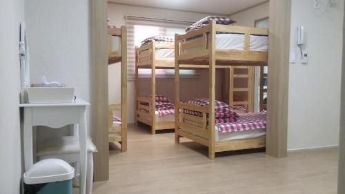 a room with three bunk beds in a room at Jiinbill in Yeosu