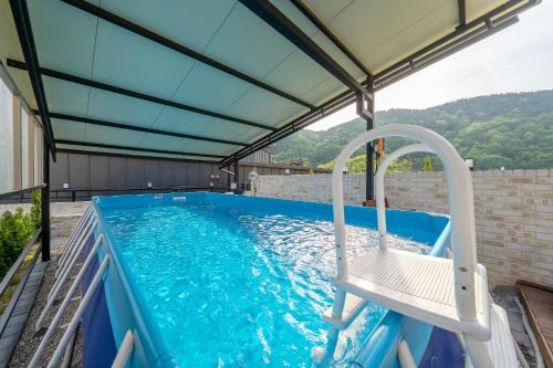 a swimming pool with a chair on a patio at Chuncheon DBJ in Chuncheon