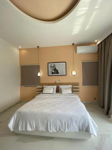 a bedroom with a large white bed with a round ceiling at Villa 49 in Abidjan