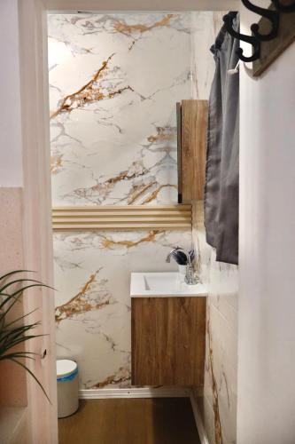 a bathroom with a sink and a marble wall at The Cozy Beach Studio in San Juan