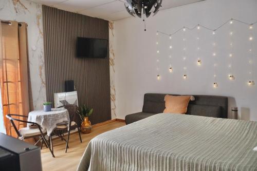 a bedroom with a bed and a couch and a table at The Cozy Beach Studio in San Juan