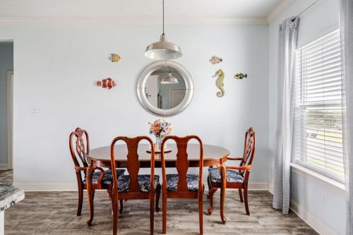 a dining room with a table and chairs and a mirror at Gulf Views Steps to Beach 2 King Beds 3Bd 2Bth in Bolivar Peninsula
