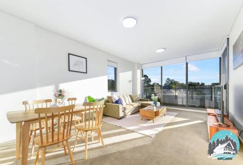 a living room with a table and chairs and a couch at Asquith 2BR Apt Secure Underground Parking in Asquith