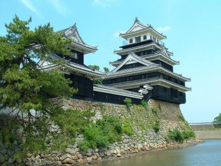 a large building on a hill next to a body of water at Grand Plaza Nakatsu Hotel in Nakatsu