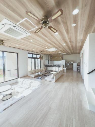a large room with white furniture and a ceiling at guest house ALO in Miyako-jima