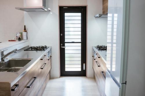 a kitchen with a sink and a door at guest house ALO in Miyako-jima