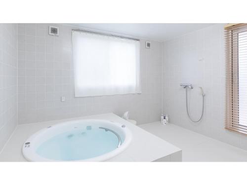 a white bathroom with a tub and a shower at TEA TREES - Vacation STAY 86532v in Tateyama