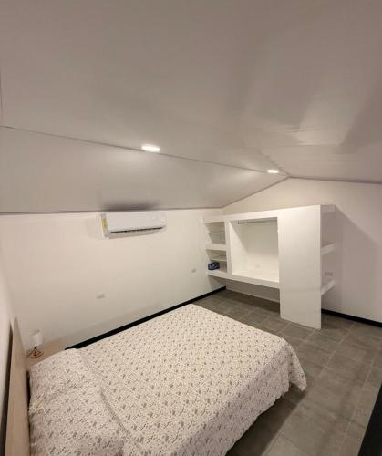 a white room with a bed and a cabinet at Apartamentos Aledu in Brasilito