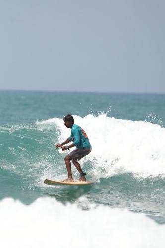 a man riding a wave on a surfboard in the ocean at Saha surf camp lesson booking only in Pottuvil