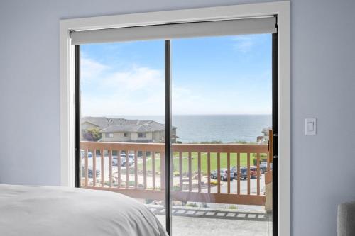 a bedroom with a sliding glass door with a view of the ocean at Seascape Ocean View Condo in Aptos