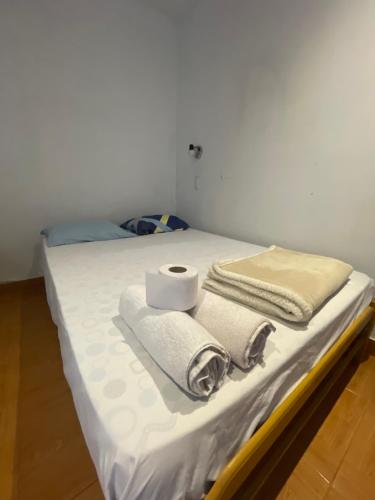 a bed with towels and a roll of toilet paper on it at Hospedaje vista del sur paracas in Paracas