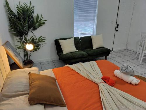a bedroom with a bed with an orange blanket at Modern studio in a prime location 112-1 in Hollywood