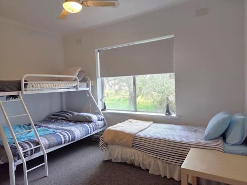 a bedroom with two bunk beds and a window at 38 at Point Turton in Point Turton
