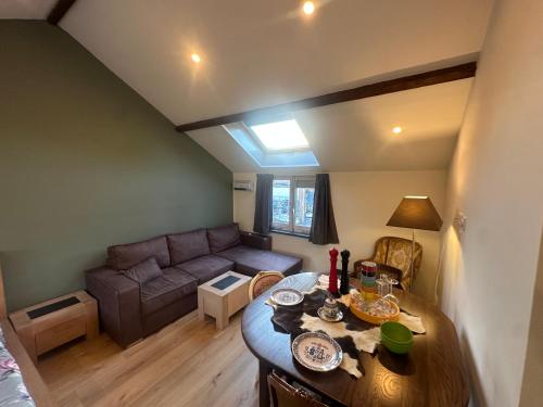 a living room with a table and a couch at Tim's Place in Groesbeek