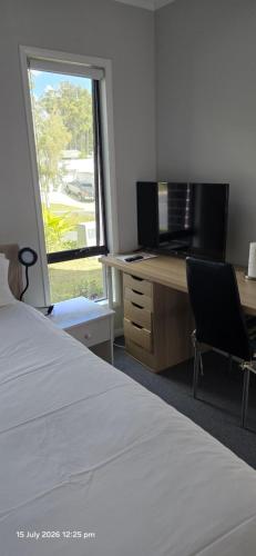 a bedroom with a bed and a desk and a window at Serene Home in Bahrs Scrub