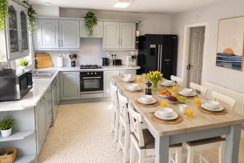 a kitchen with a large wooden table with white cabinets at Ardee Retreat - Sleeps 6, Garden, Walk to Town in Ardee
