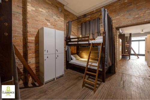 a room with bunk beds in a brick wall at The Clarence Park in Toronto
