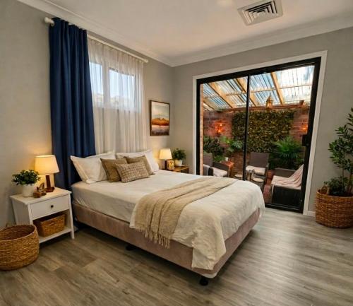 a bedroom with a large bed and a large window at The Nest in Bidwill
