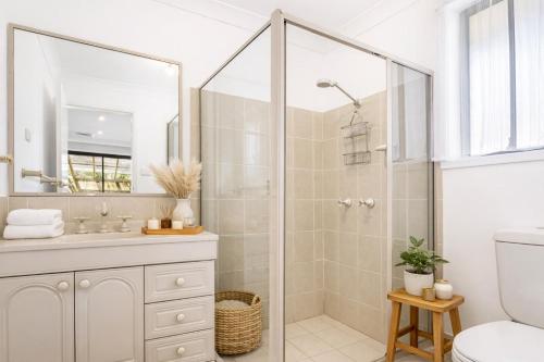 a white bathroom with a shower and a toilet at The Nest in Bidwill