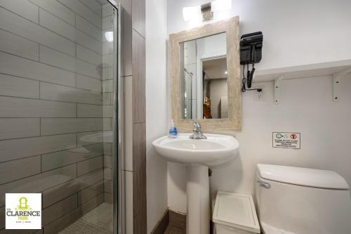 a bathroom with a sink and a toilet and a mirror at The Clarence Park in Toronto
