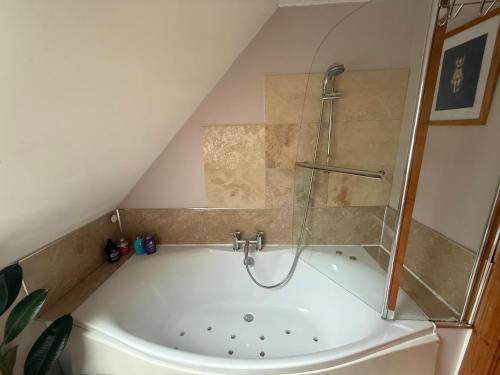 a attic bathroom with a shower and a tub at Laimhrig Lockley in Torrin