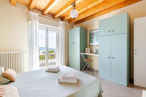 a bedroom with a bed and a desk and a window at Casa con ampio terrazzo, vista lago e giardino in Toscolano Maderno