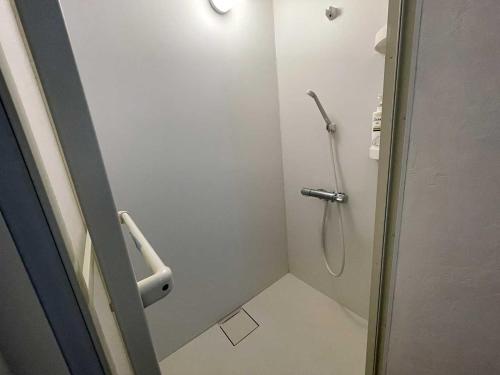 a bathroom with a shower stall with a shower curtain at kODATEL Hakodate Ocean in Hakodate
