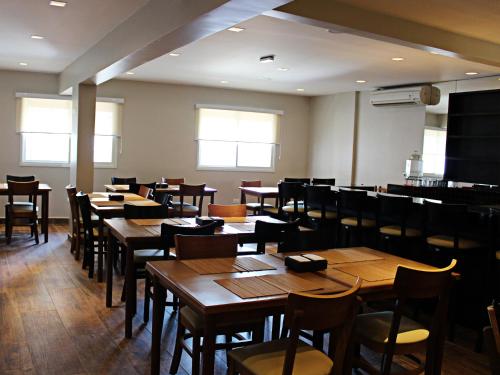 a dining room with wooden tables and chairs at SW Praia Hotel in Praia Grande