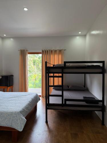 a bedroom with two bunk beds and a window at Norwil Manor Tagaytay in Tagaytay