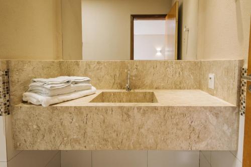 a bathroom with a sink and a mirror at Rosa Vilma Hotel in Chapadão do Sul