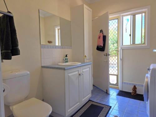 a bathroom with a toilet and a sink and a window at Willenby in Wallaroo