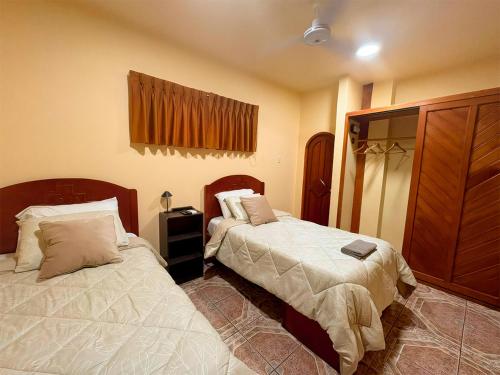 a bedroom with two beds and a dresser at Casa del Jaguar in Iquitos