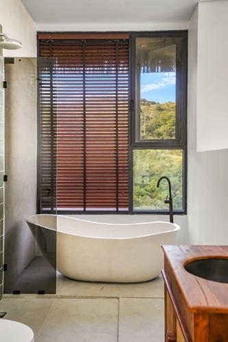 a bath tub in a bathroom with a window at Makai Lombok in Selong Belanak
