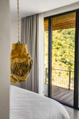 a chandelier hanging over a bed in front of a window at Makai Lombok in Selong Belanak