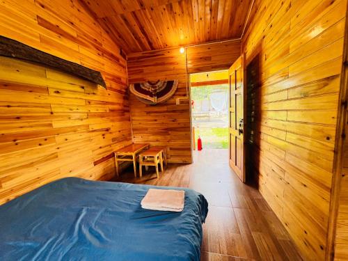 a log cabin bedroom with a bed and a table at B & M Homes in Tả Van